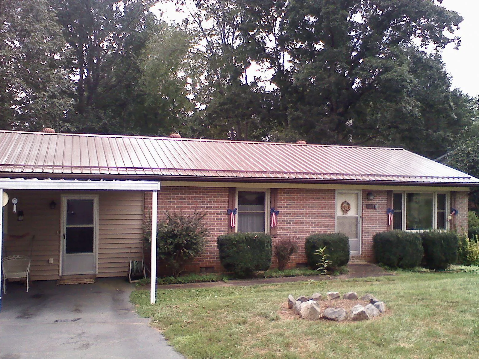 Bronze metal roof and carport on a brick ranch home — Roof Repair work by our crew in Star